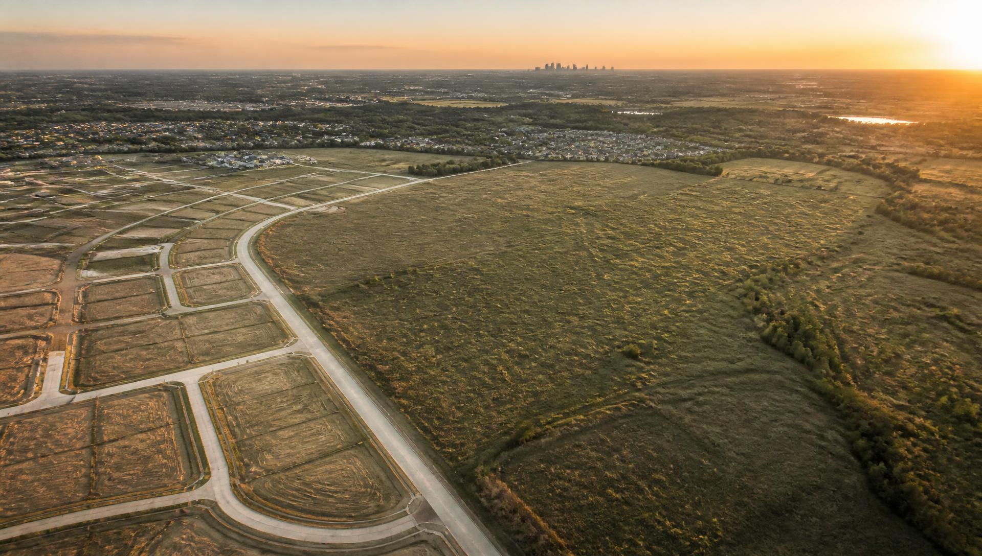 Aerial view of graded residential development lots bordering open land in the Dallas–Fort Worth area